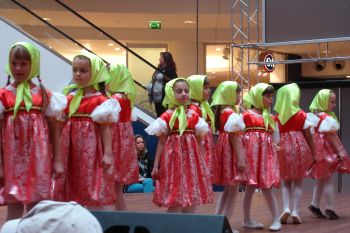 tanzende junge Mädchen im roten Kleid und gelbem Kopftuch